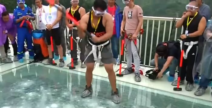 Chine:Des bénévoles frappent à coups de masse un pont avec des parois de verre pour vérifier sa solidité (vidéo)